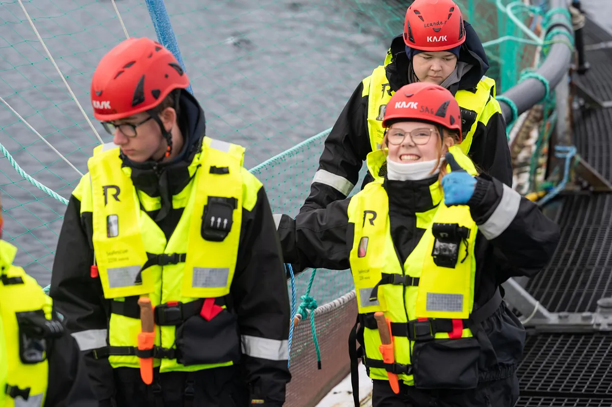 Ungdommer med hjelm og redningsvest går langs merder